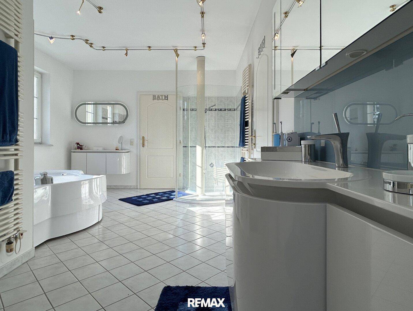 Elegantes Badezimmer mit Doppelwaschbecken, großer Dusche und Whirlpool.