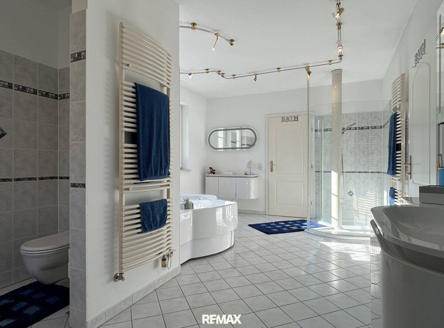 Modernes Badezimmer mit Toilette, beheiztem Handtuchhalter und geräumiger Dusche.
