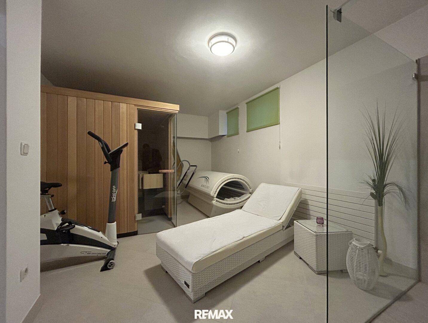 Exklusiver Wellnessbereich mit Sauna, Fitnessgeräten und Entspannungsliegen.