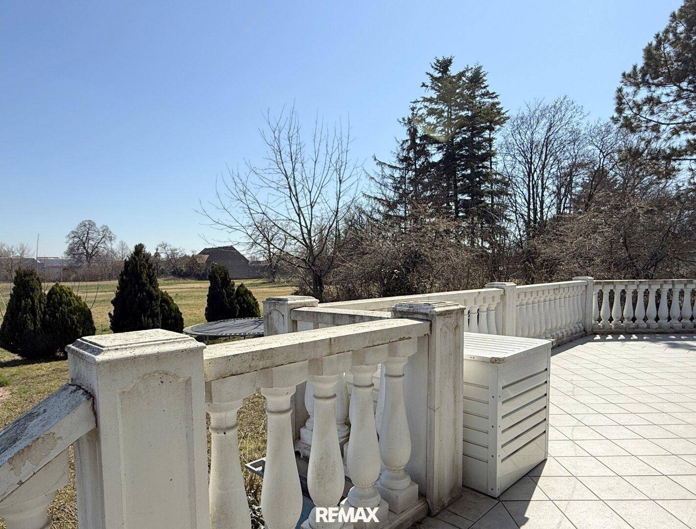 Große Terrasse mit Balustrade und weitem Blick ins Grüne und auf die Landschaft.