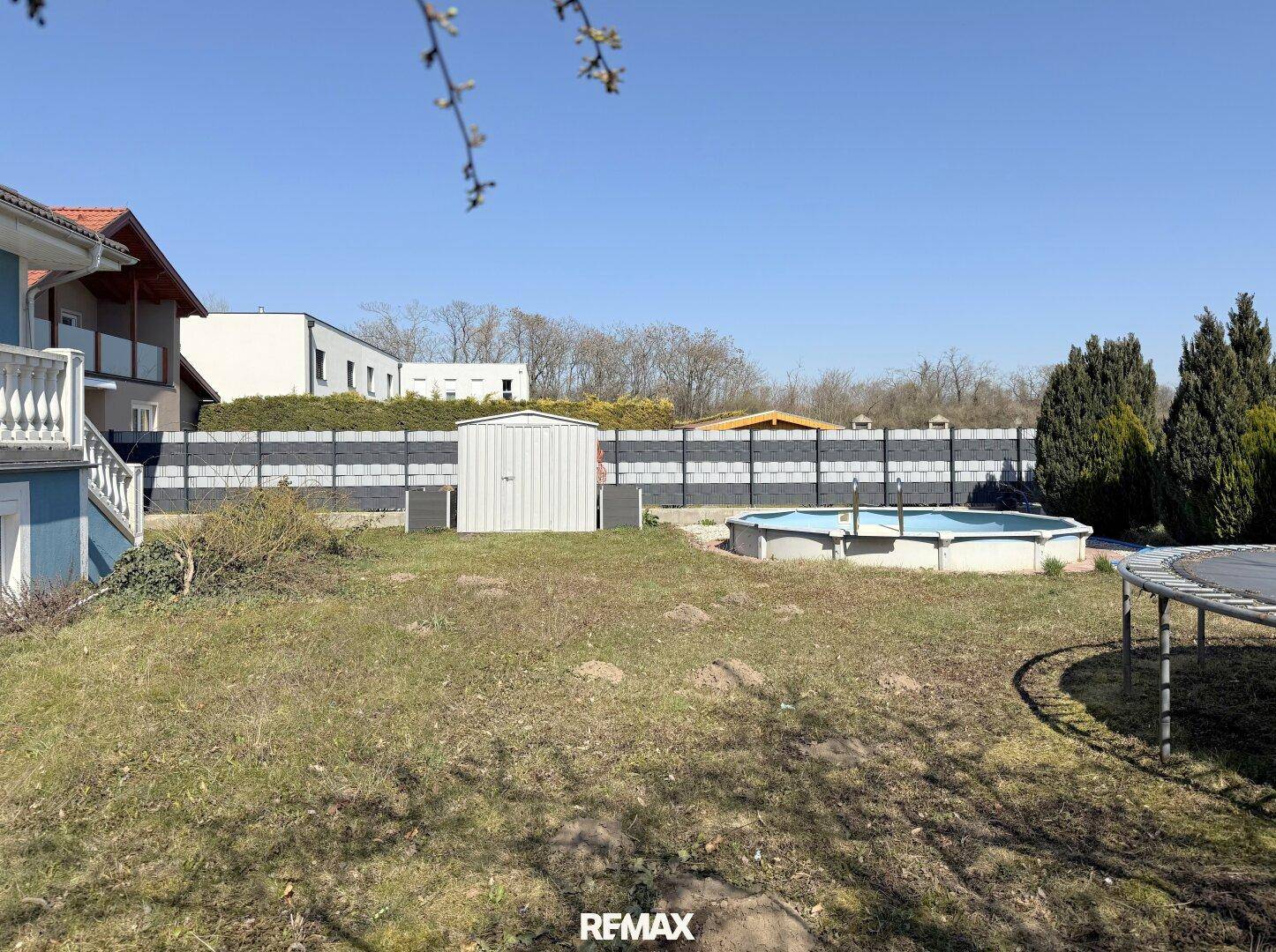 Großer Gartenbereich mit Rasenfläche, Aufstellpool, Trampolin und Gartenhaus, ideal für Freizeitaktivitäten.