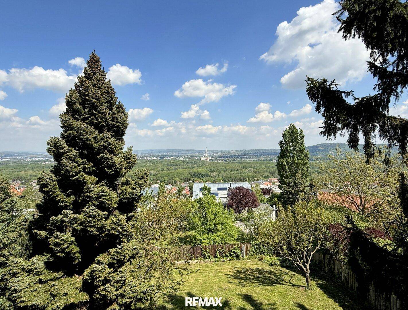 Panoramablick über die grüne Landschaft und die Umgebung unter einem strahlend blauen Himmel.