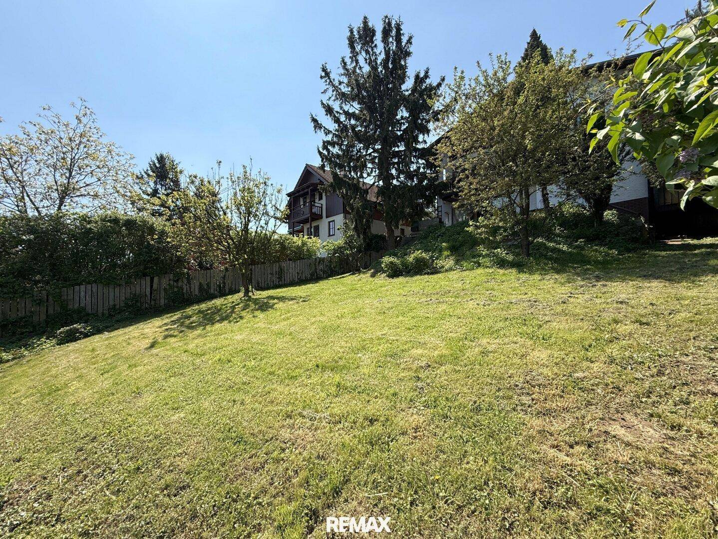 Großer, gepflegter Garten mit Rasenfläche und Bäumen, ideal für Erholung im Freien.