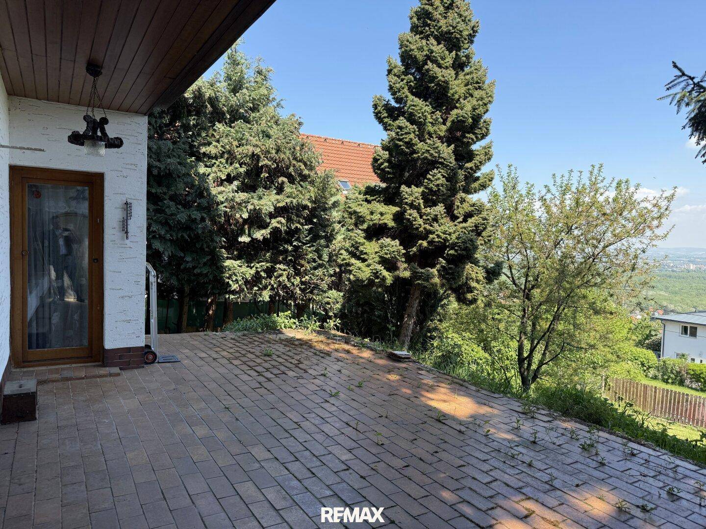 Geräumige gepflasterte Terrasse mit Blick ins Grüne, ideal für entspannte Stunden im Freien.