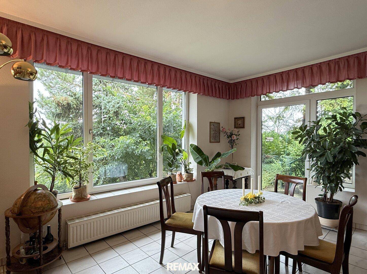 Heller Essbereich mit großem Fenster, das viel Tageslicht und einen Blick ins Grüne bietet.