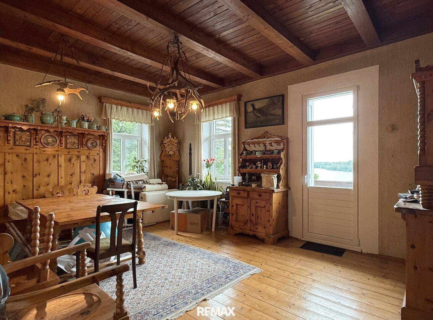 Rustikaler Essbereich mit Holzboden, Holzbalkendecke und traditionellen Möbeln.