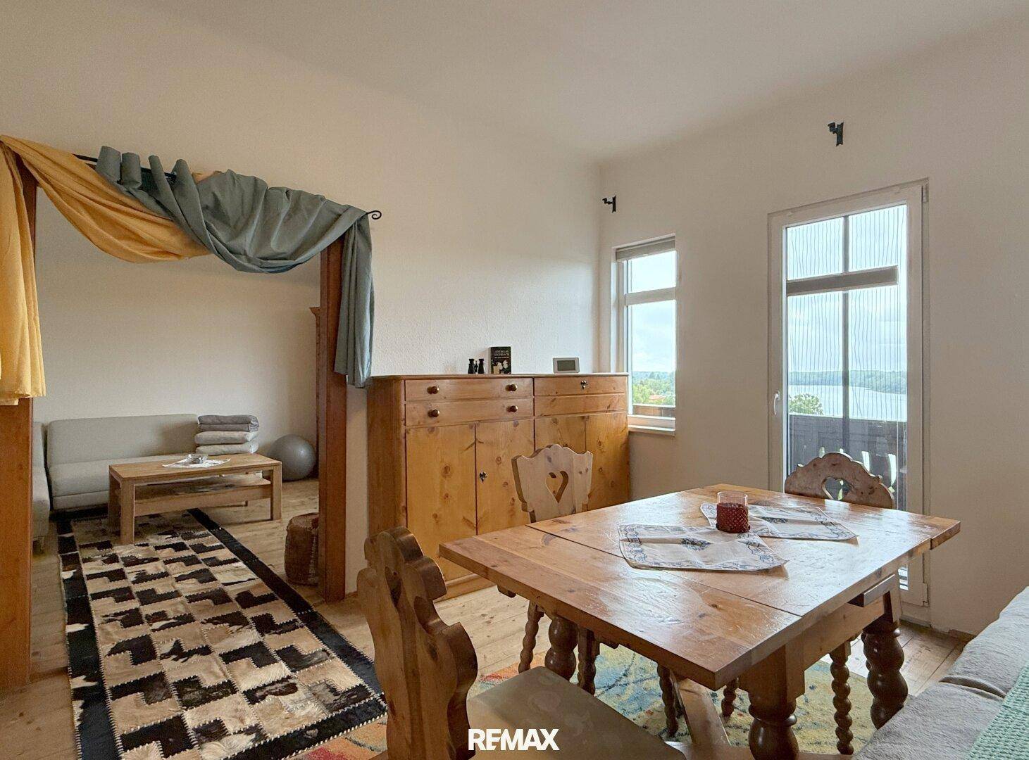 Schlafzimmer mit Holzboden, rustikalen Möbeln und Blick auf die Umgebung.