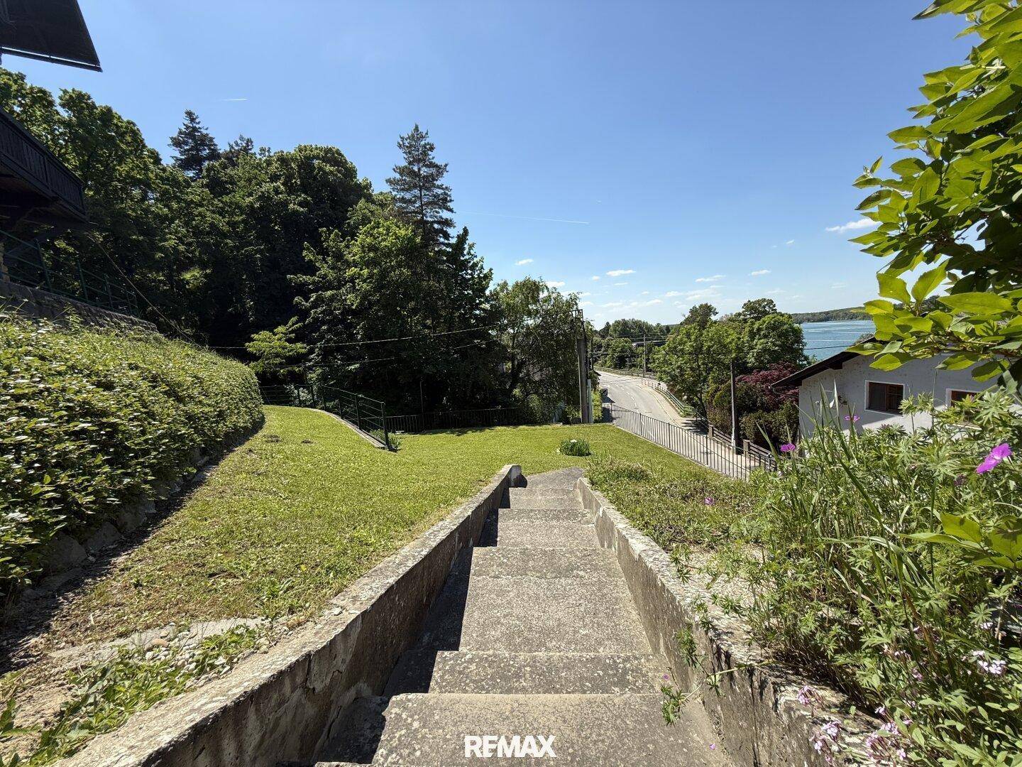 Steintreppe im Freien, umgeben von Grün mit Blick auf die ländliche Umgebung.