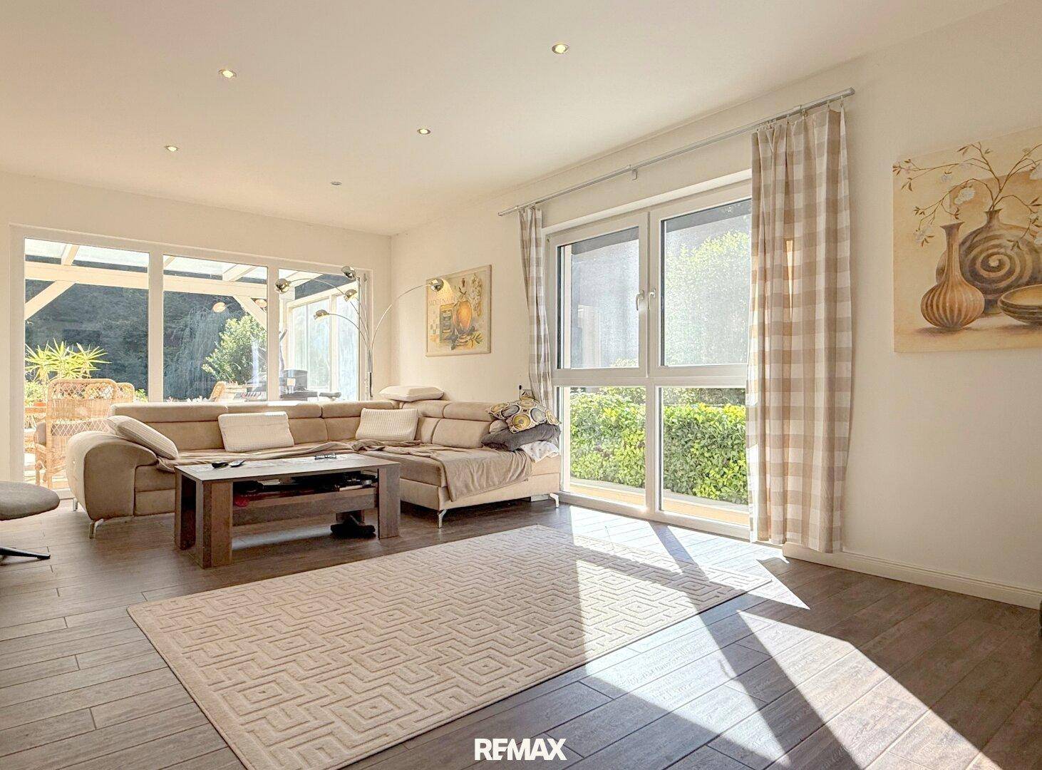 Gemütliches Wohnzimmer mit großem Sofa, Holzboden und Zugang zur Terrasse.