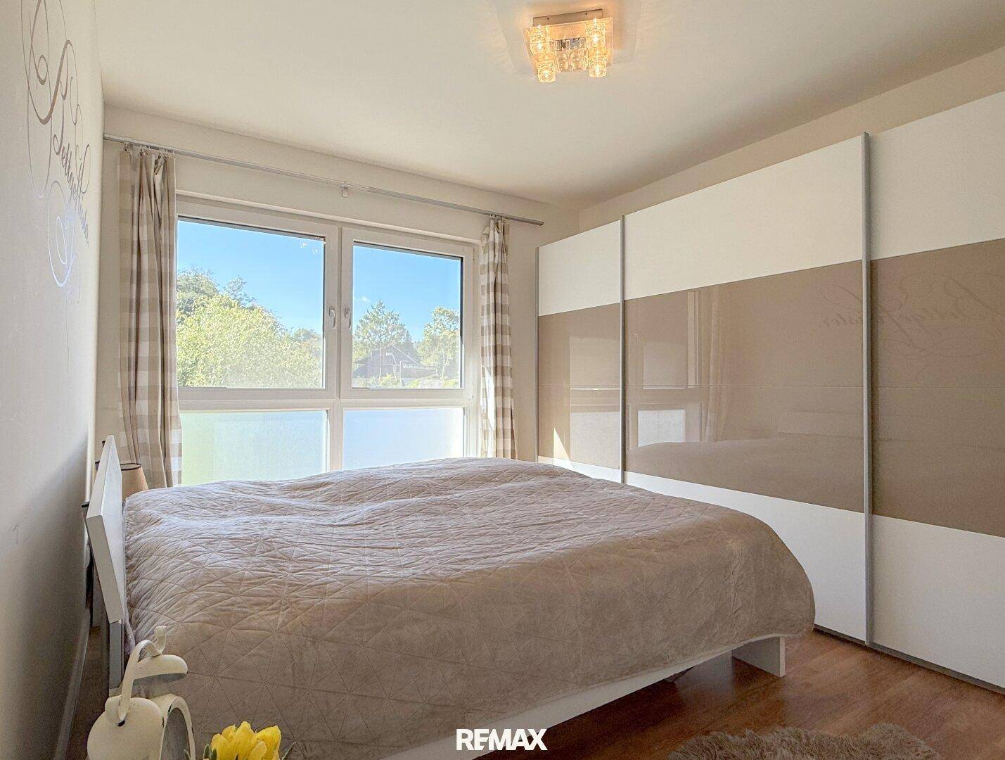 Gemütliches Schlafzimmer mit Doppelbett, Einbauschrank und Blick ins Grüne.