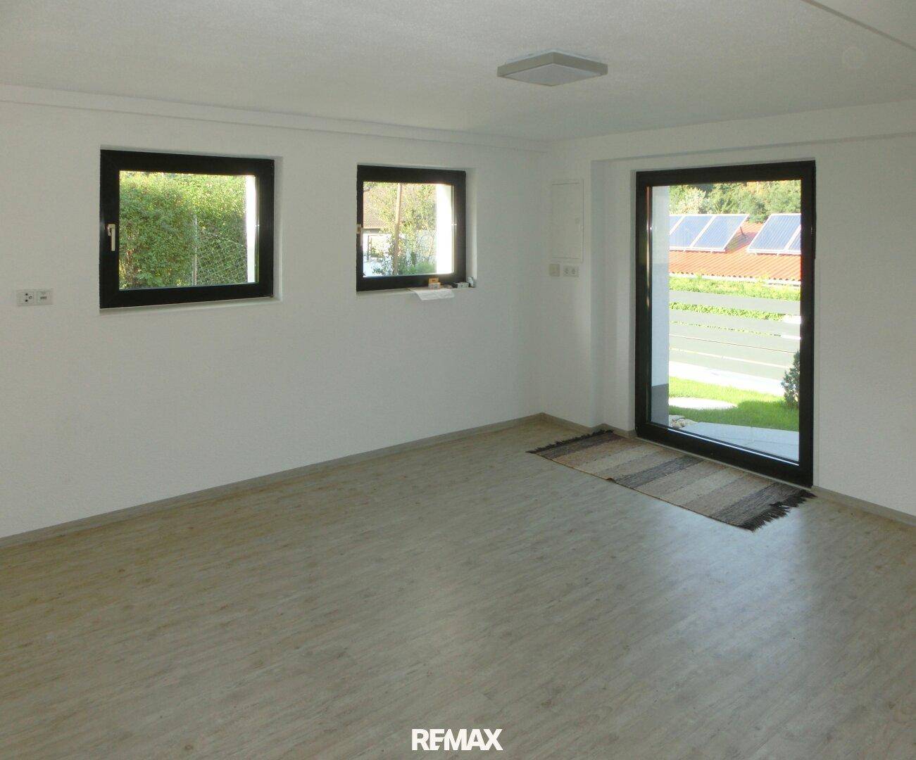 Heller Kellerraum mit direktem Zugang nach draußen und strapazierfähigem Laminatboden.