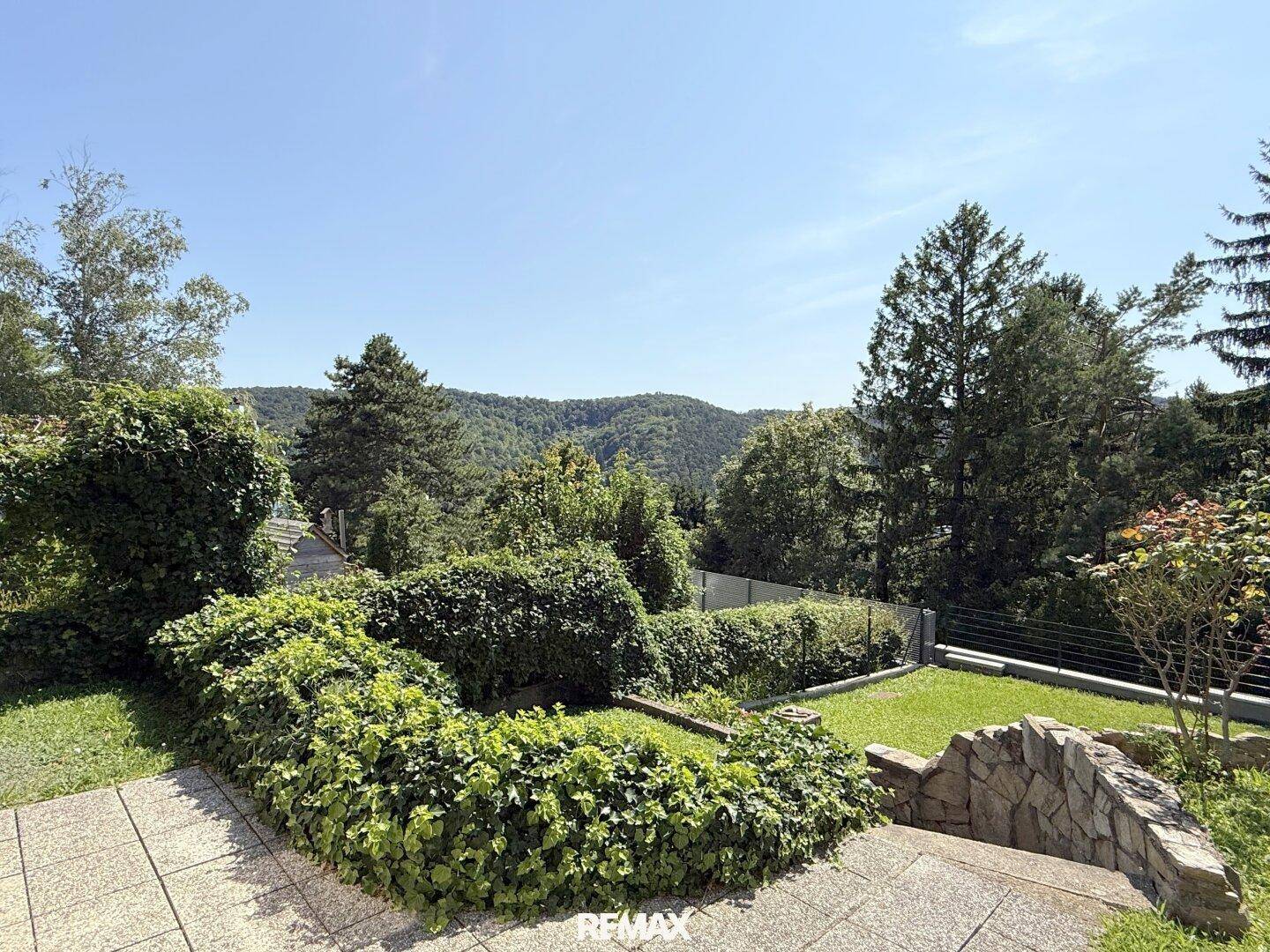Terrassierter Gartenbereich mit üppiger Bepflanzung und weitem Blick ins Grüne.