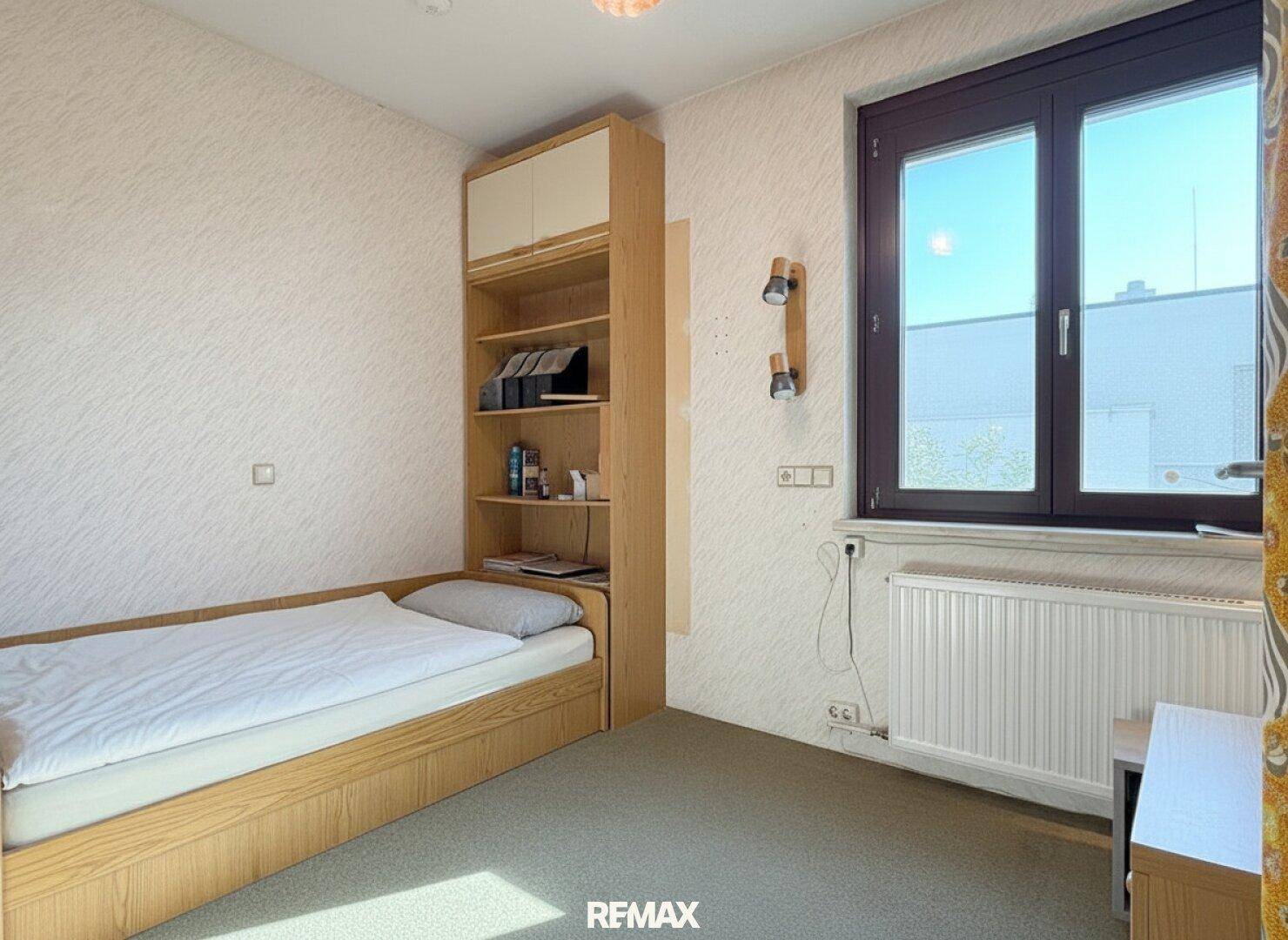 Gemütliches Kinderzimmer mit Einzelbett, Regal und Fenster, ideal für junge Bewohner.