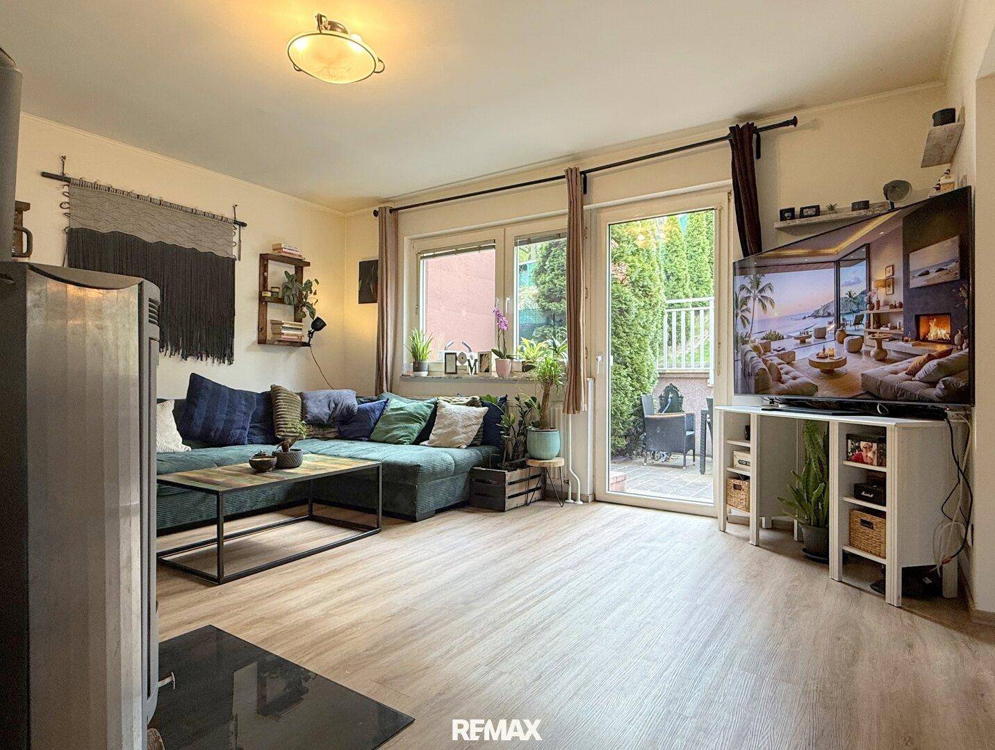 Heller Wohnbereich mit Terrassenzugang, Kaminofen und gemütlicher Einrichtung.