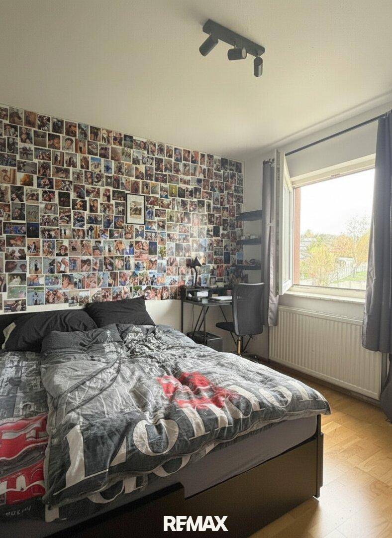 Individuell gestaltetes Schlafzimmer mit Bett, Schreibtisch und Fenster.