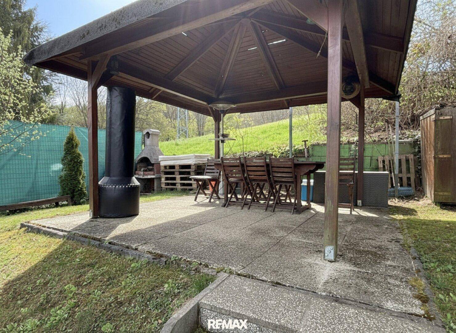 Geräumiger Holzpavillon mit Esstisch und Stühlen, ideal für Mahlzeiten im Freien.