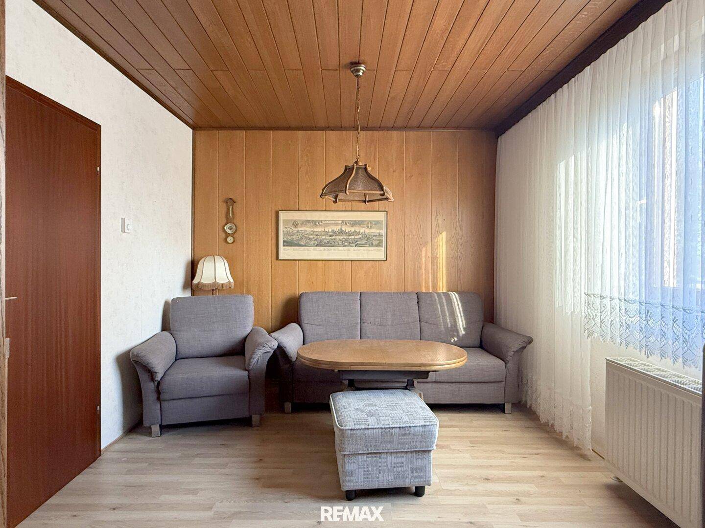 Gemütliches Wohnzimmer im Vintage-Stil mit Holzvertäfelung und bequemen Sofas.