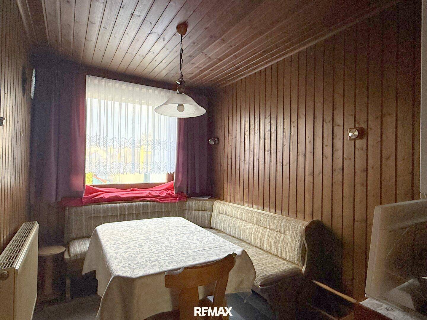 Essbereich mit Holztäfelung, Eckbank und Esstisch, ideal für gemütliche Mahlzeiten.