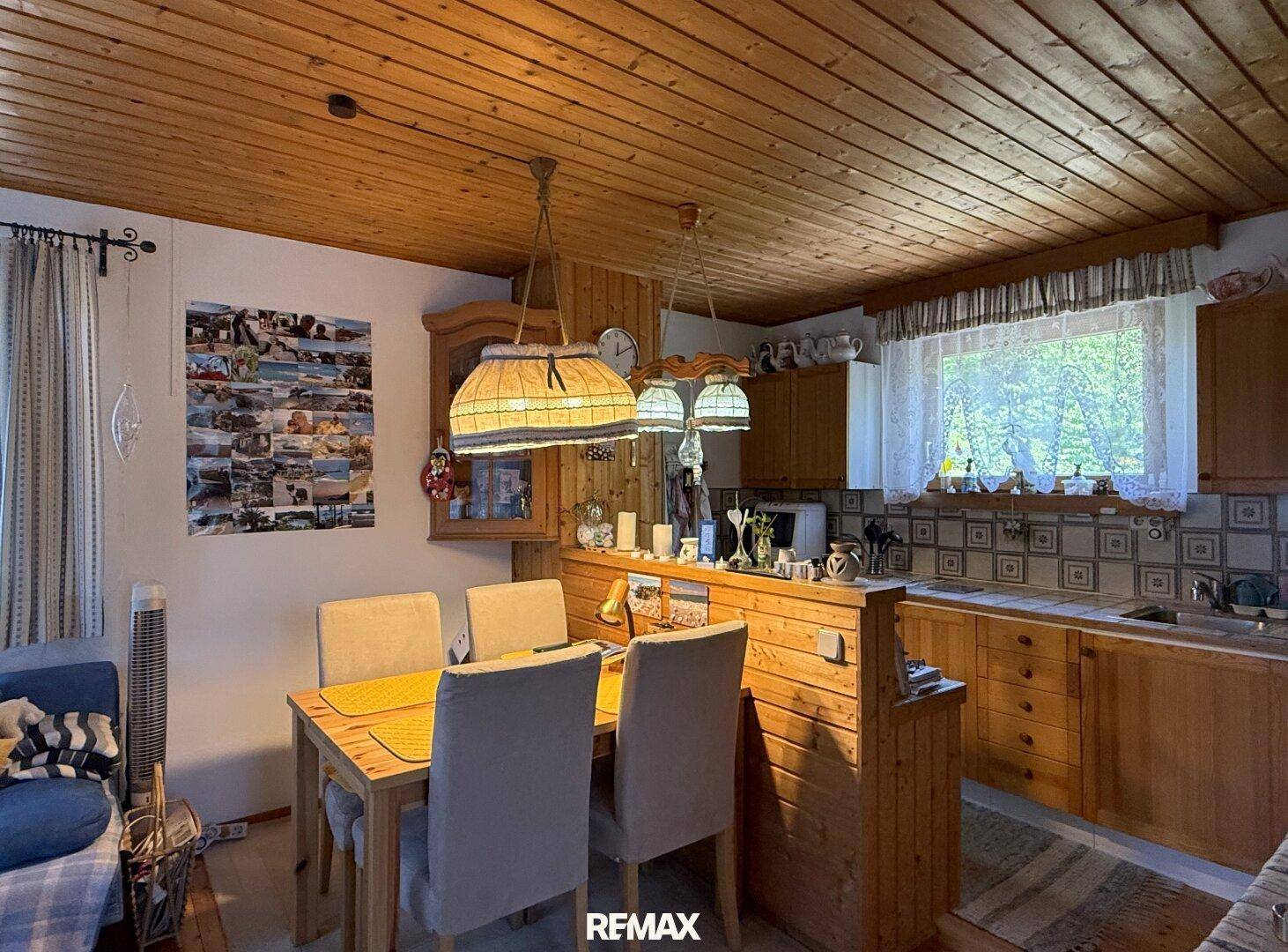 Gemütlicher Essbereich mit Holztisch und Stühlen, angrenzend an eine traditionelle Küche.