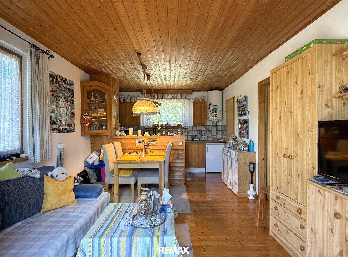 Offener Wohn- und Essbereich mit Holzelementen und integrierter Küche im Landhausstil.