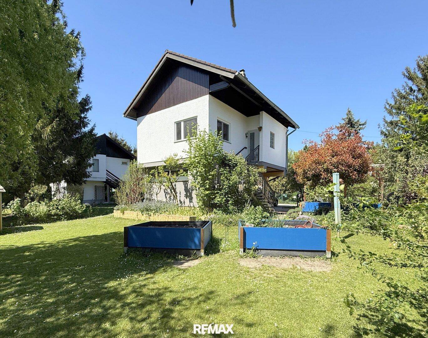 Freistehendes Haus mit großem, gepflegtem Garten und Hochbeeten für den Anbau.