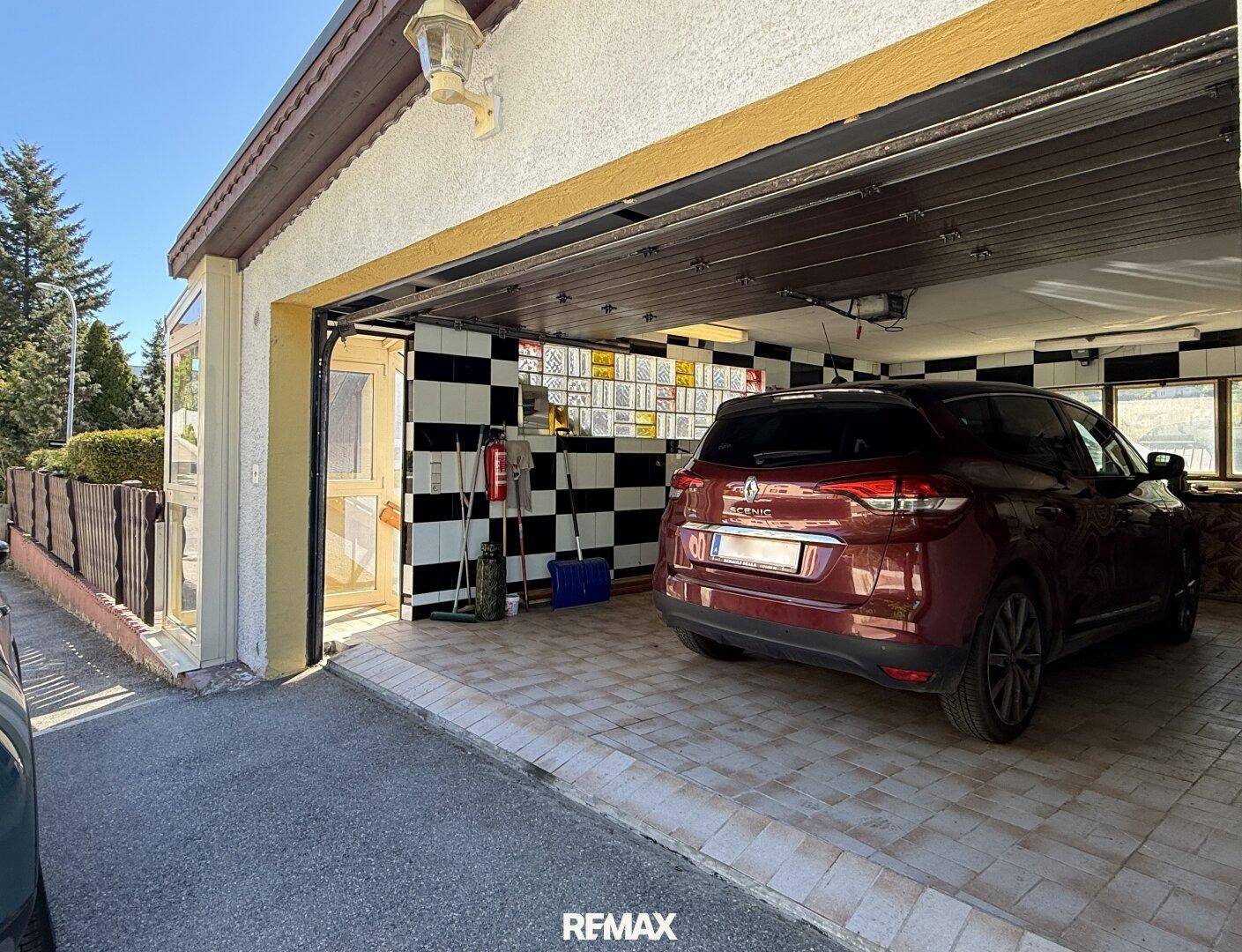 Geräumige Garage mit Fliesenboden und Platz für ein Fahrzeug.