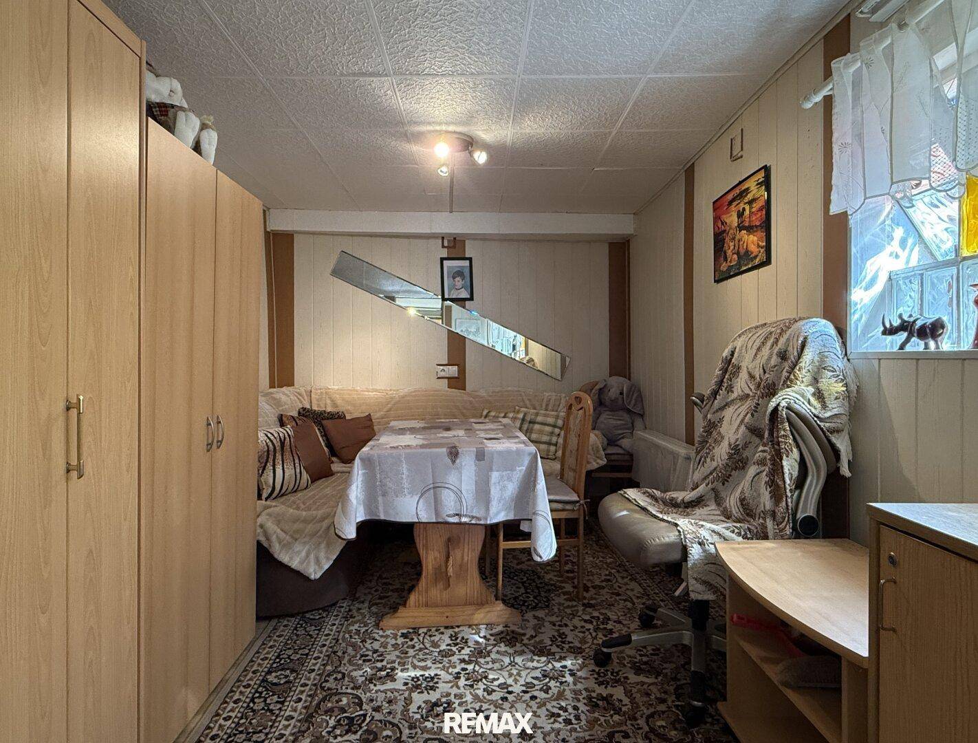 Gemütlicher Wohnbereich im Untergeschoss mit Teppichboden und Sitzgruppe.
