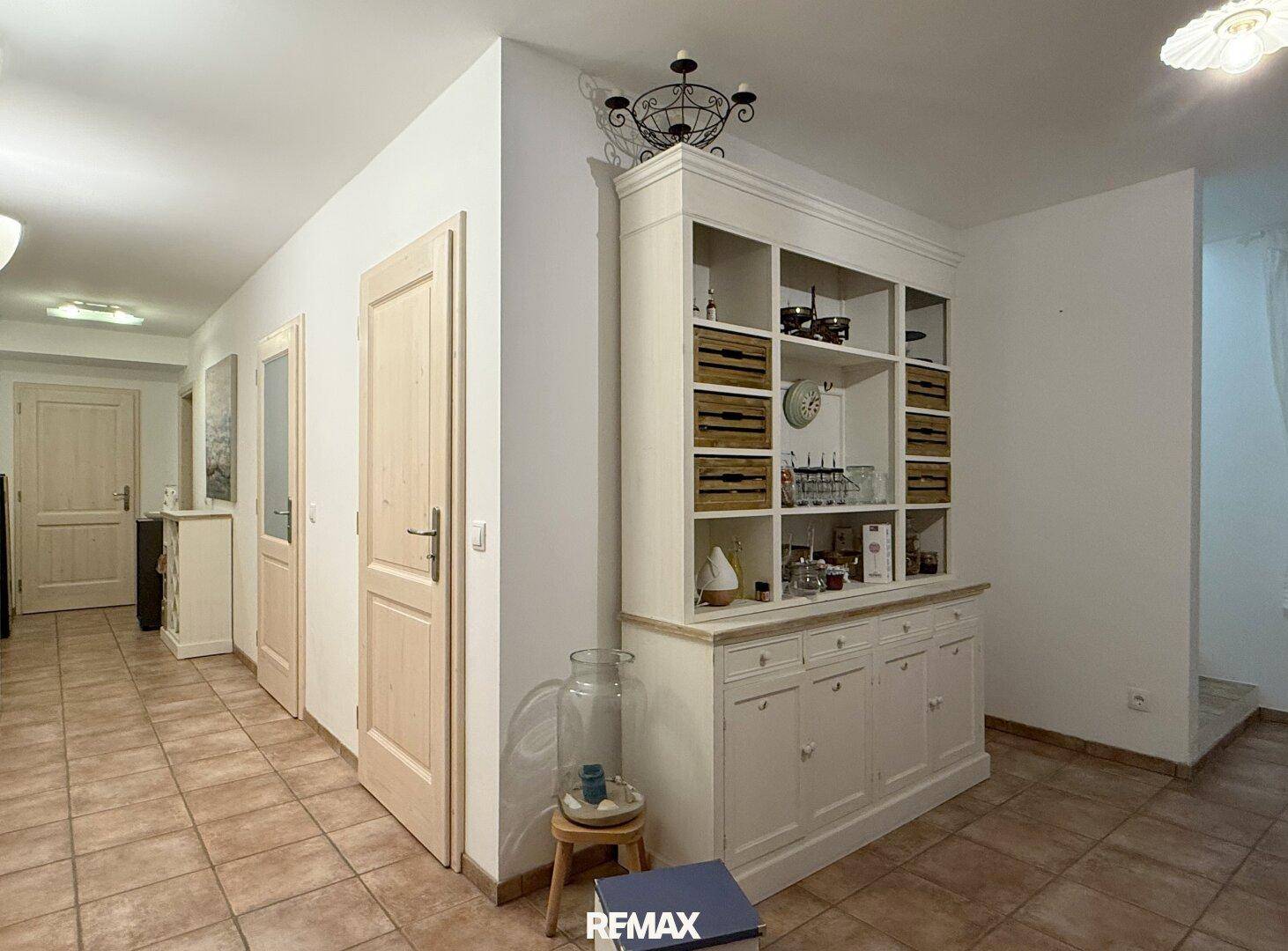 Geräumiger Flur mit Terrakottafliesen und einem großen weißen Schrank.