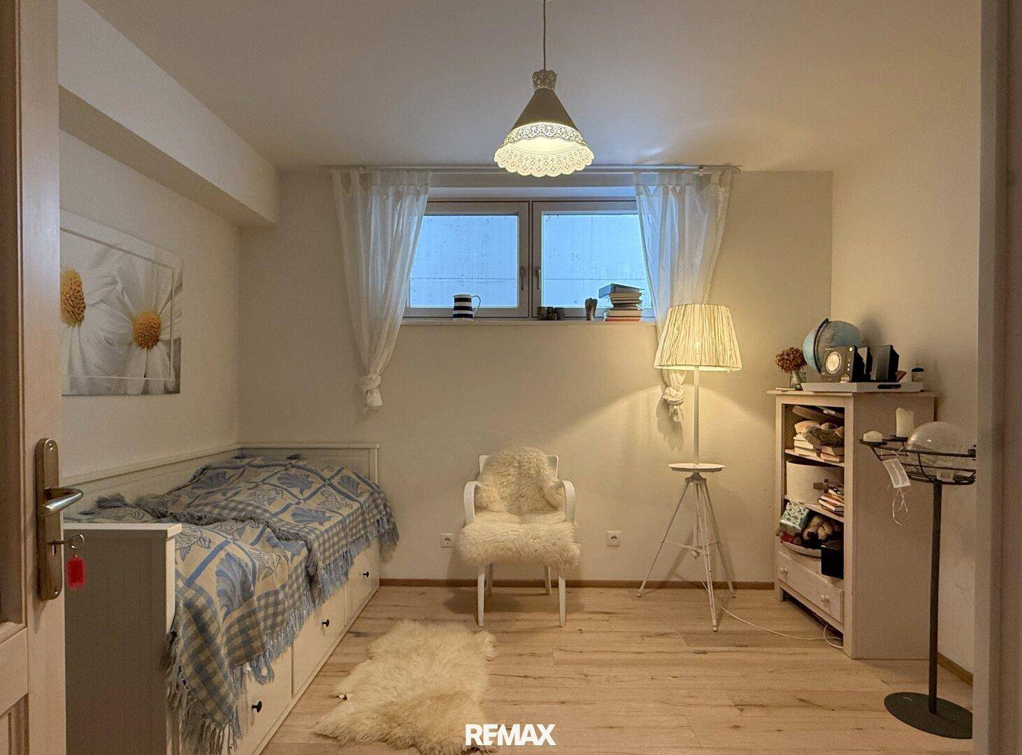 Gemütliches Schlafzimmer mit Einzelbett, Fenster und hellem Holzboden.