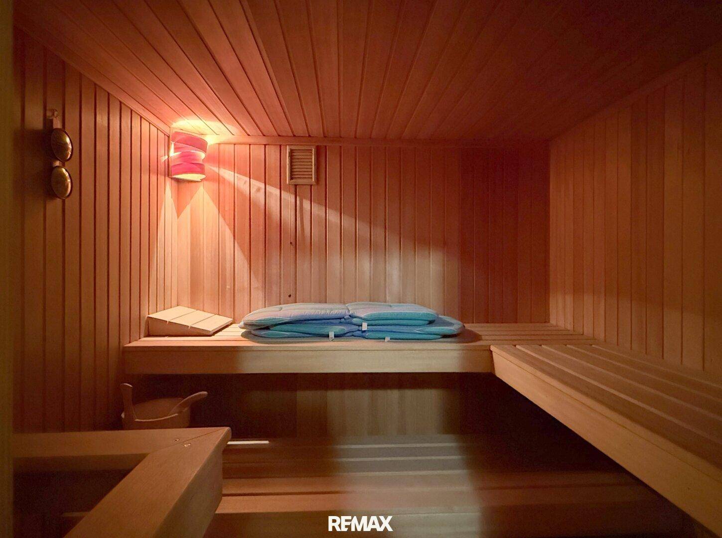 Gemütliche Holzsauna mit Bänken und stimmungsvoller Beleuchtung für Entspannung.