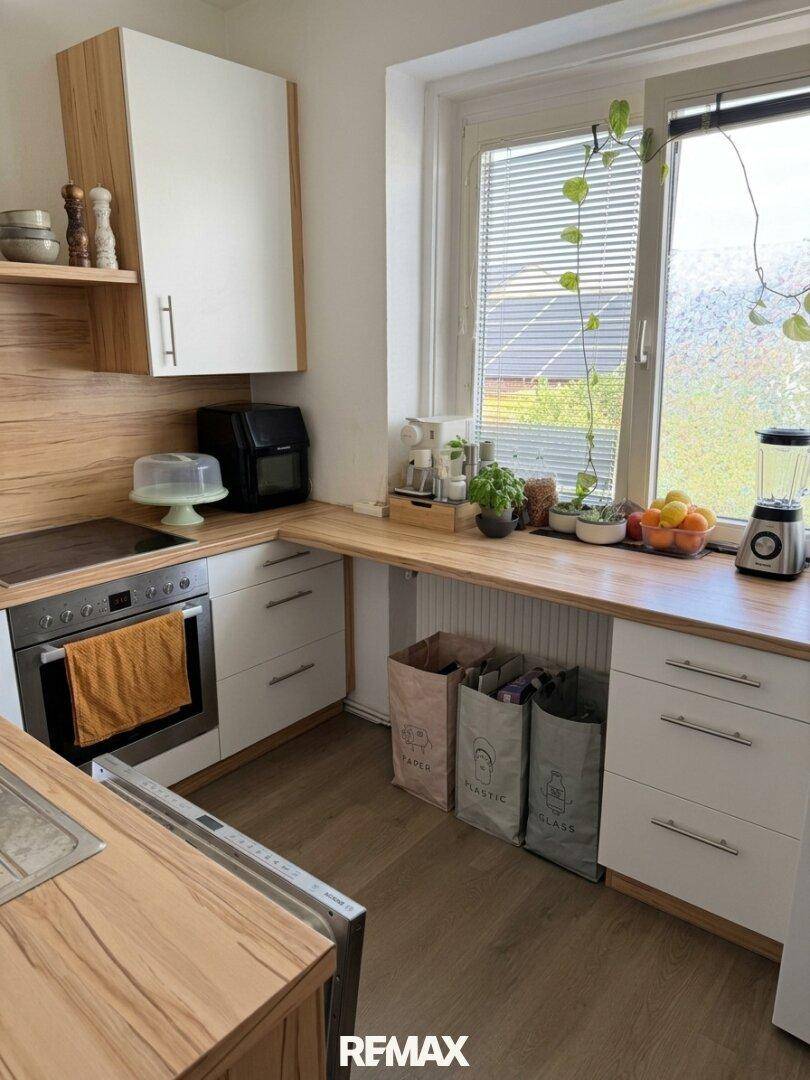 Moderne Küche mit Holz- und weißen Fronten, Fenster und integrierten Geräten.