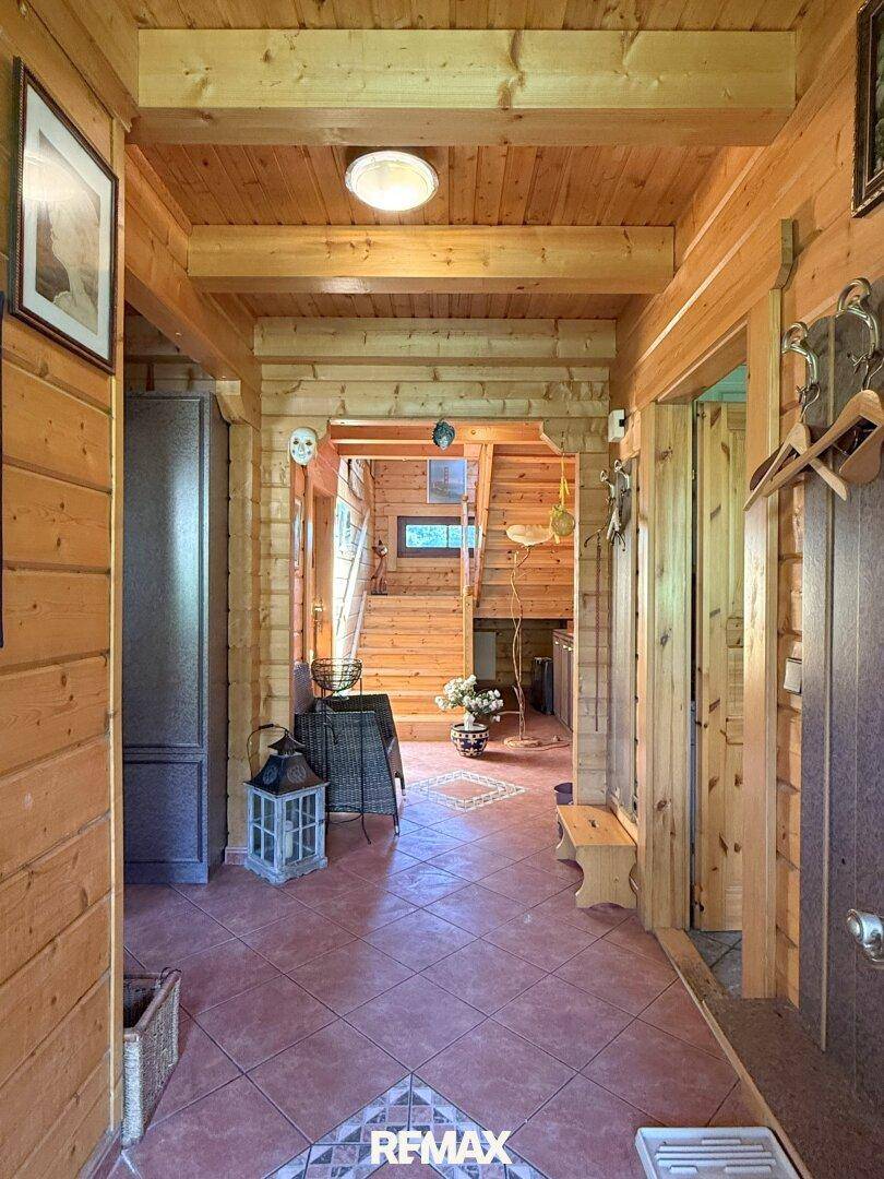 Gemütlicher Eingangsbereich mit Holzvertäfelung, Fliesenboden und Treppenaufgang.