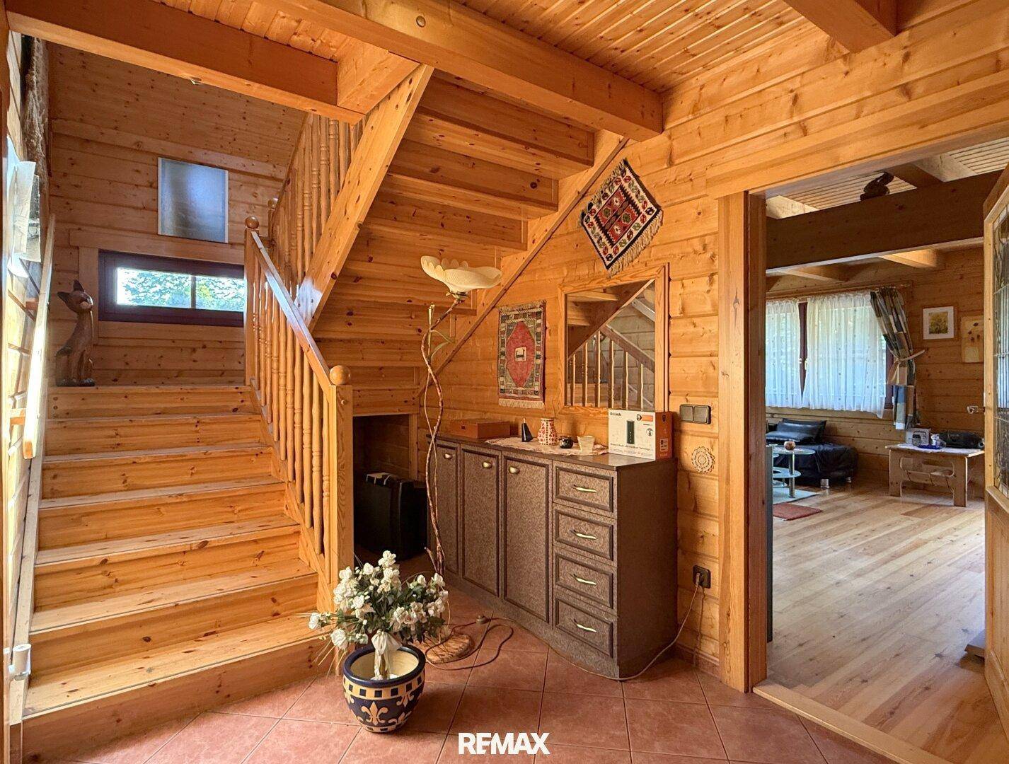 Geräumiger Flur mit Holztreppe, Fliesenboden und Zugang zu den Wohnbereichen.