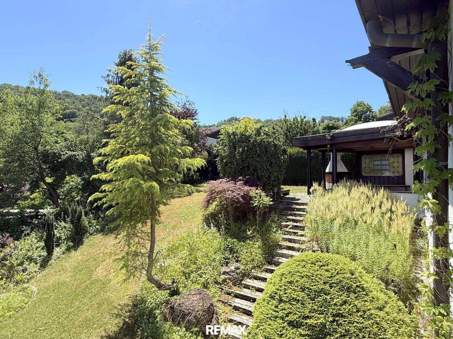Grüner, terrassierter Garten mit Treppen und üppiger Vegetation.