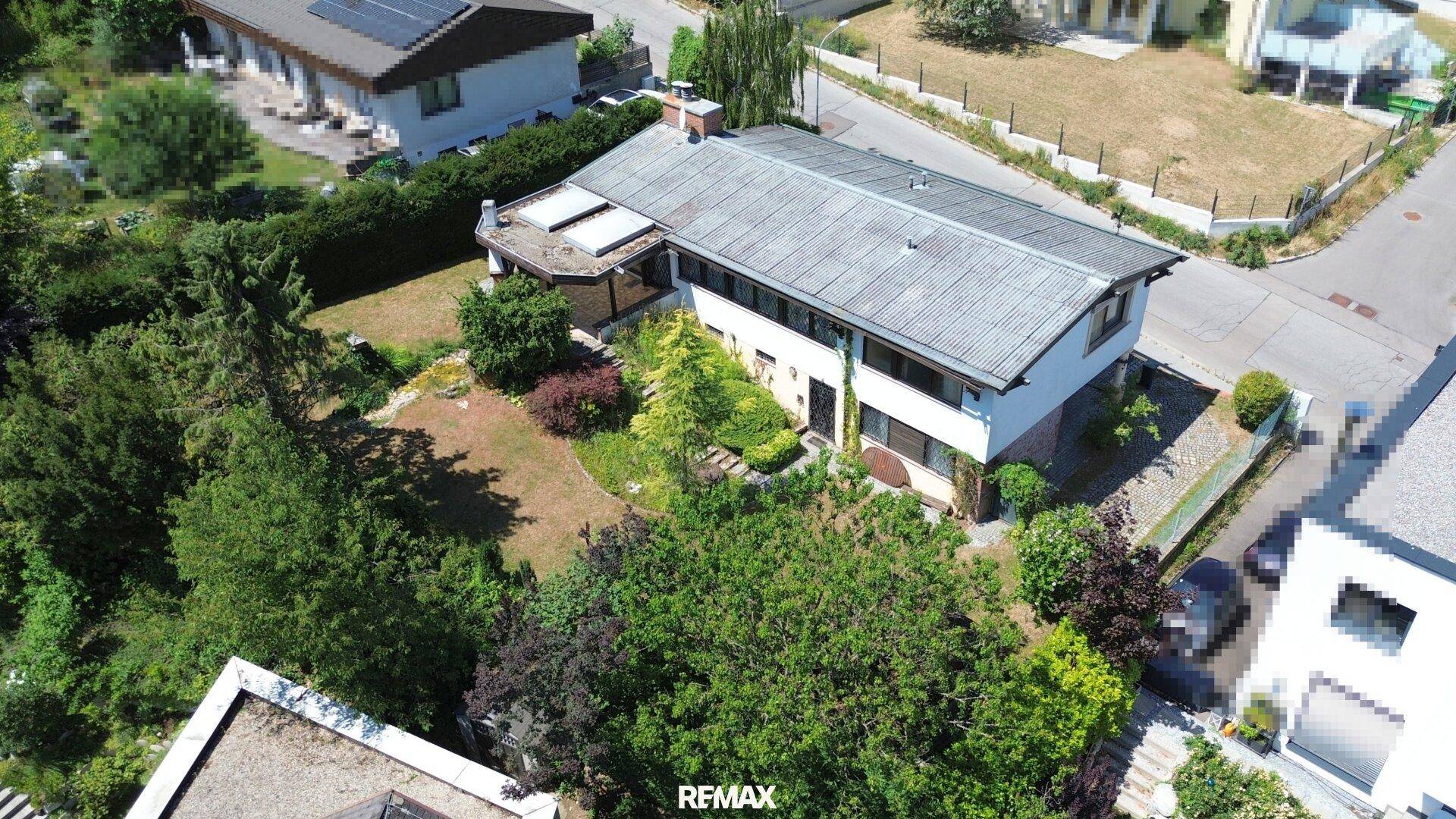 Luftaufnahme des Einfamilienhauses mit großem Garten und umliegender Wohngegend.