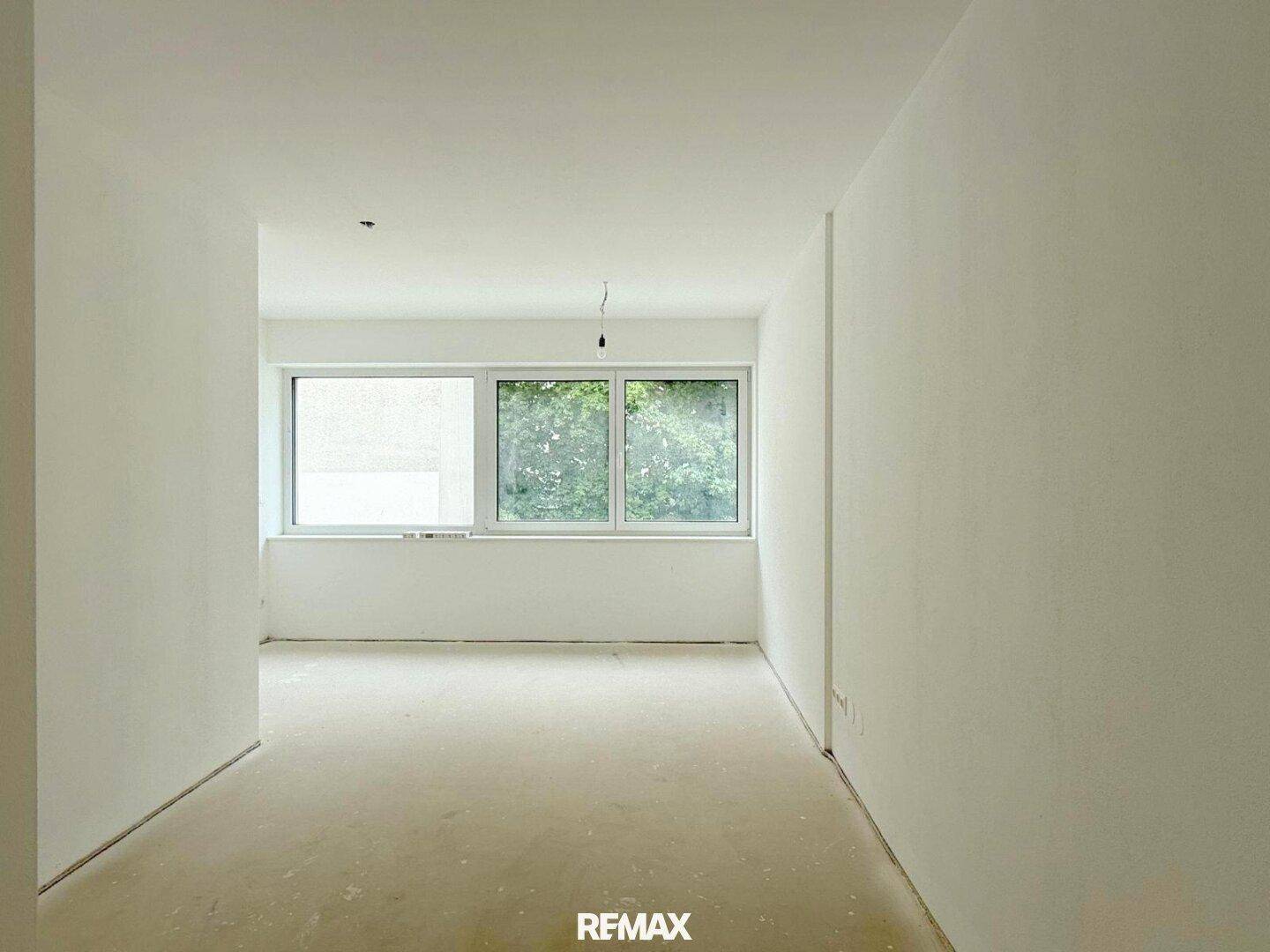 Geräumiges Schlafzimmer im Rohbau mit viel Tageslicht und Ausblick.