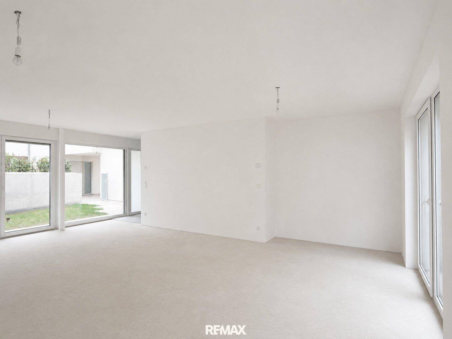 Geräumiges, unfertiges Wohnzimmer mit großen Fenstern und viel Tageslicht, bereit für die Gestaltung.