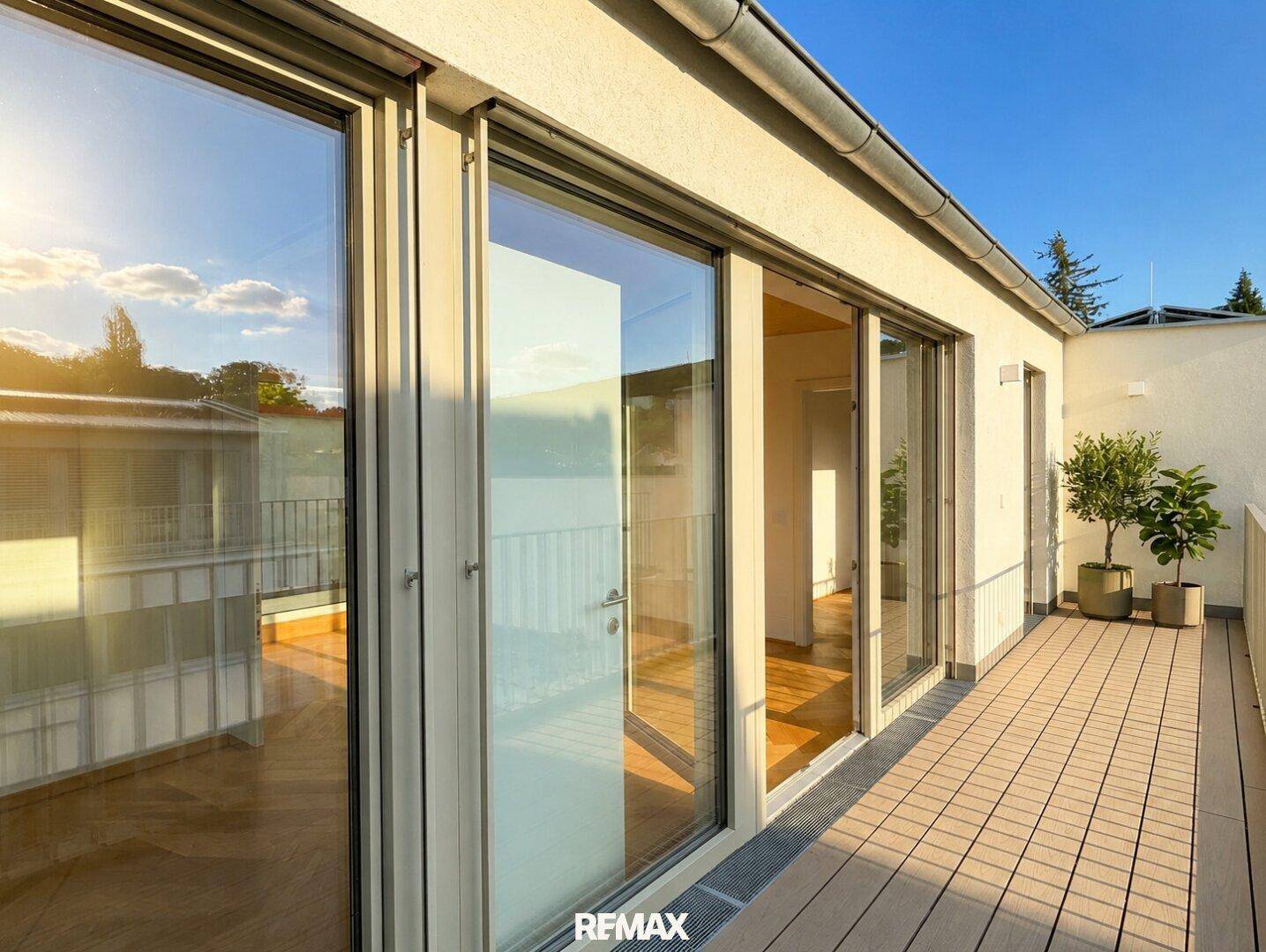 Sonnige Dachterrasse mit Holzboden und Blick auf die Umgebung, ideal zum Entspannen.