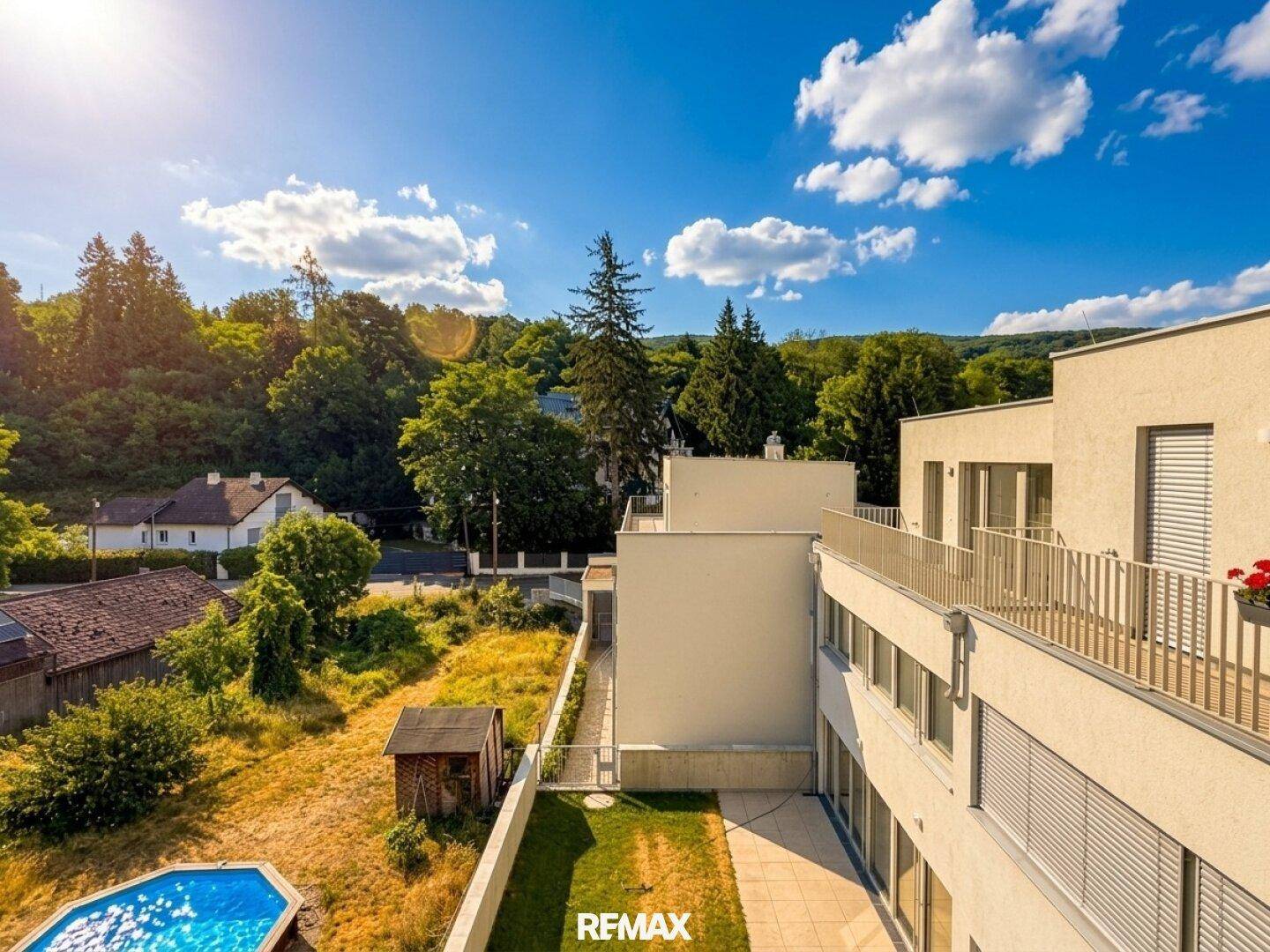 Weitläufiger Blick auf die Wohnanlage mit Pool, Garten und umliegender grüner Landschaft.