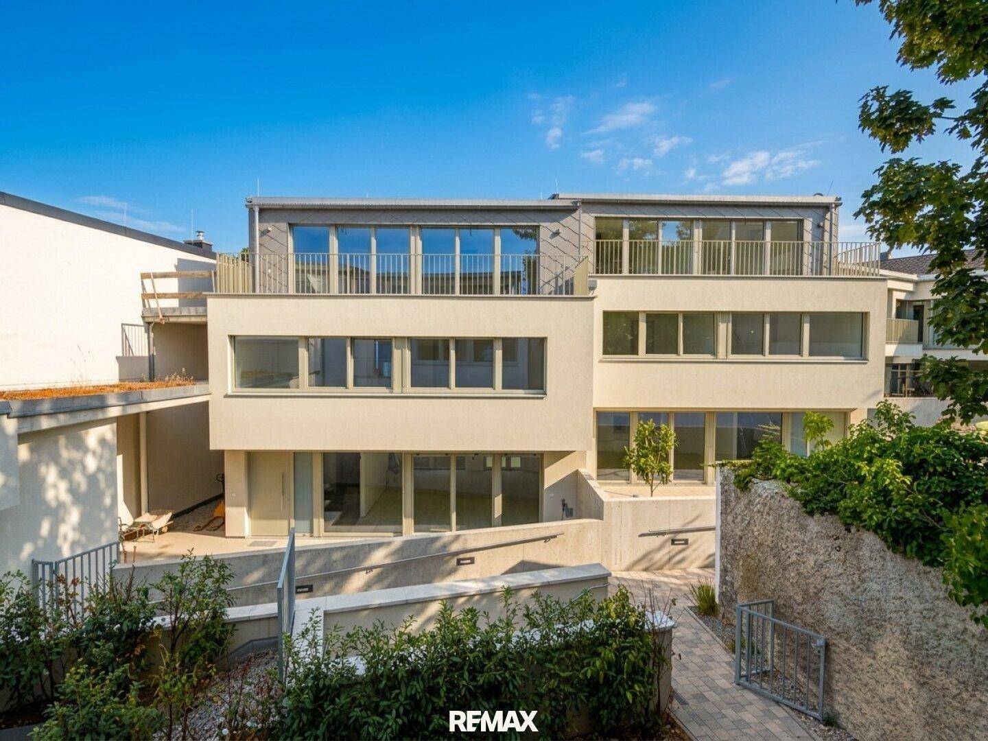 Ansicht der modernen Wohnanlage mit mehreren Etagen, großen Fensterfronten und Balkonen.