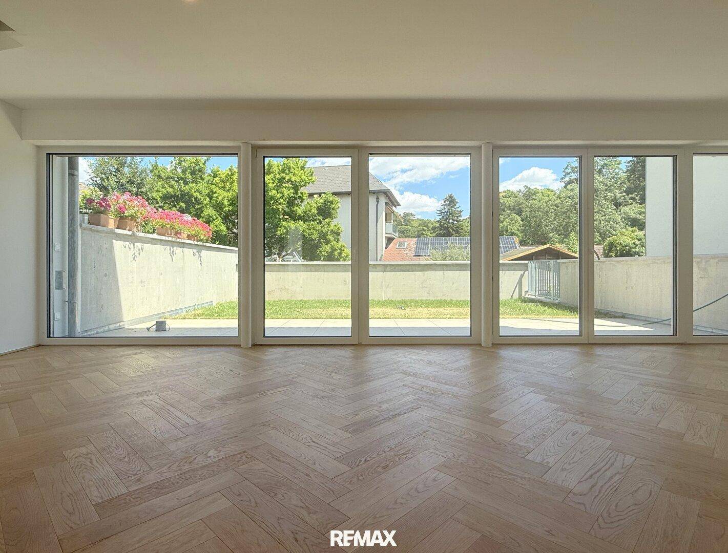 Große Fensterfront im Wohnbereich bietet einen schönen Blick auf den grünen Garten.