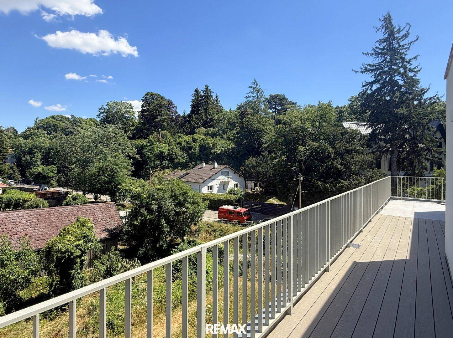 Sonniger Balkon mit weitem Blick über die grüne Landschaft und die Umgebung.