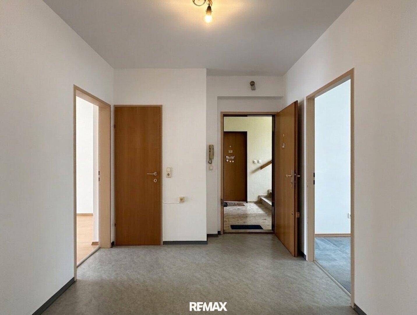 Heller Flur mit mehreren Holztüren, der Zugang zu verschiedenen Räumen der Wohnung bietet.