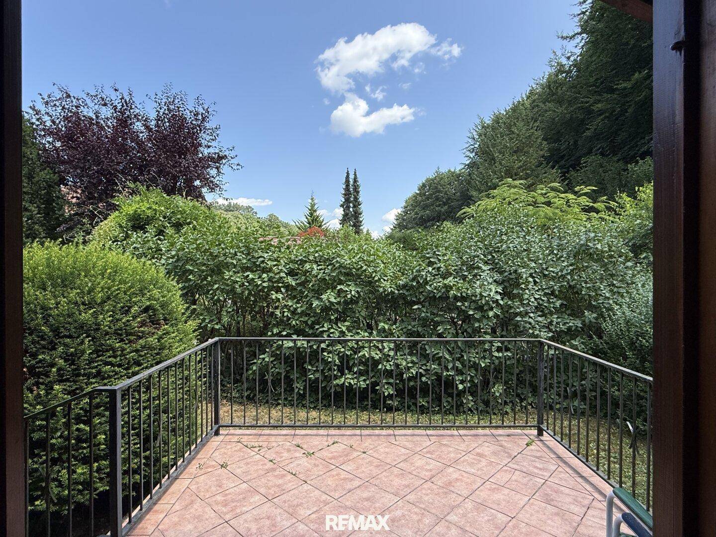 Weitläufiger Blick von der Terrasse auf die grüne Umgebung und den blauen Himmel.