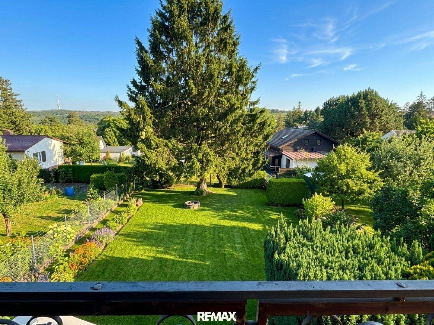 Weitläufiger Blick vom Balkon über den großen, gepflegten Garten und die Umgebung.