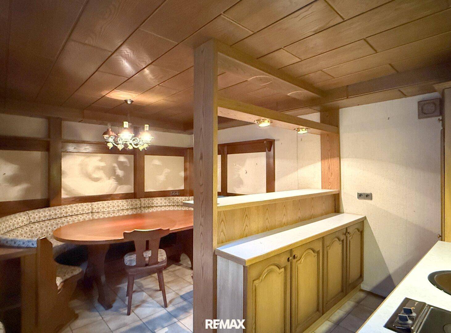 Rustikale Kellerküche mit Essbereich, Holzdecke und traditionellen Möbeln.