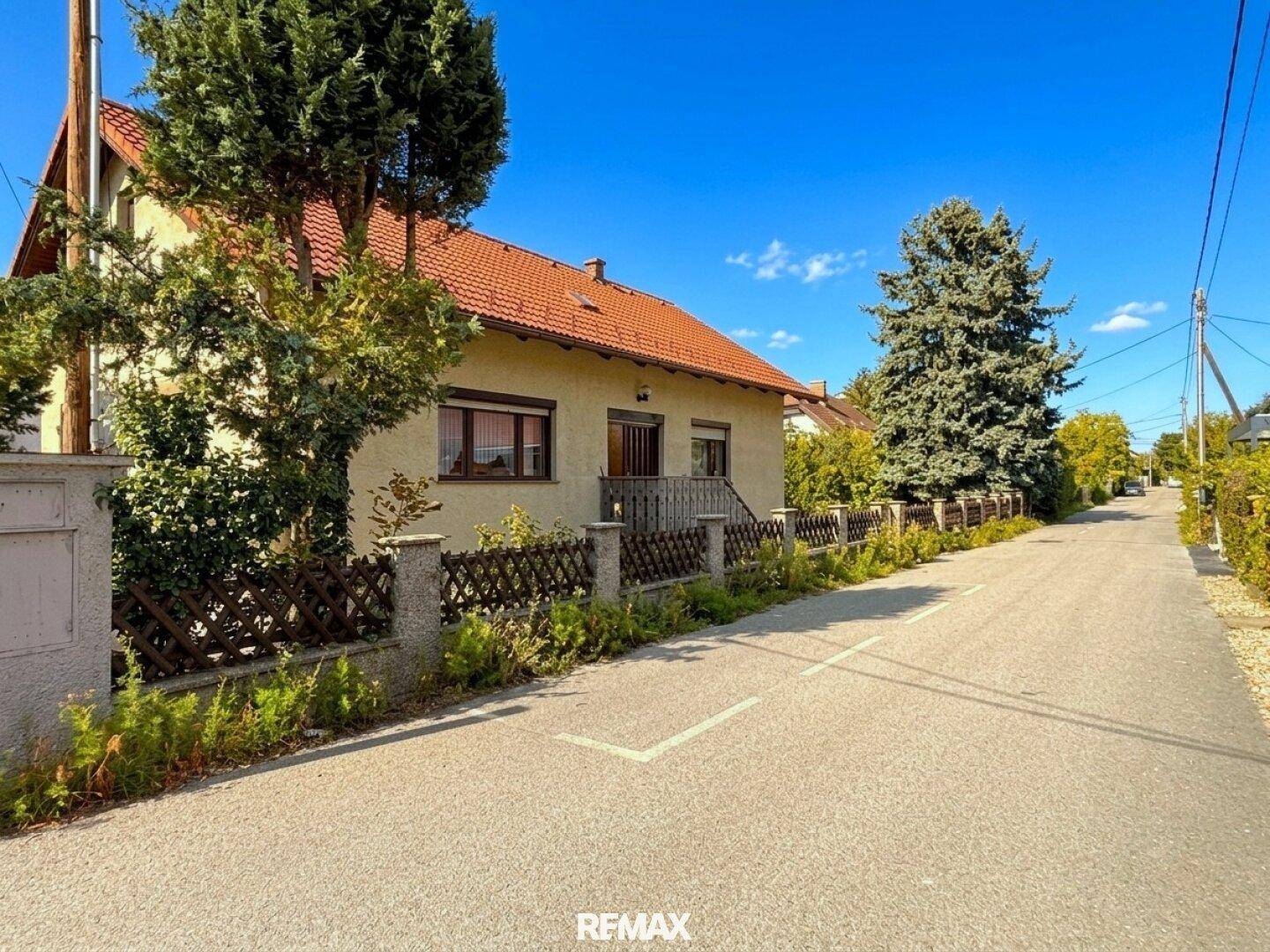 Ruhige Wohnstraße mit Blick auf das Einfamilienhaus und grüne Umgebung.
