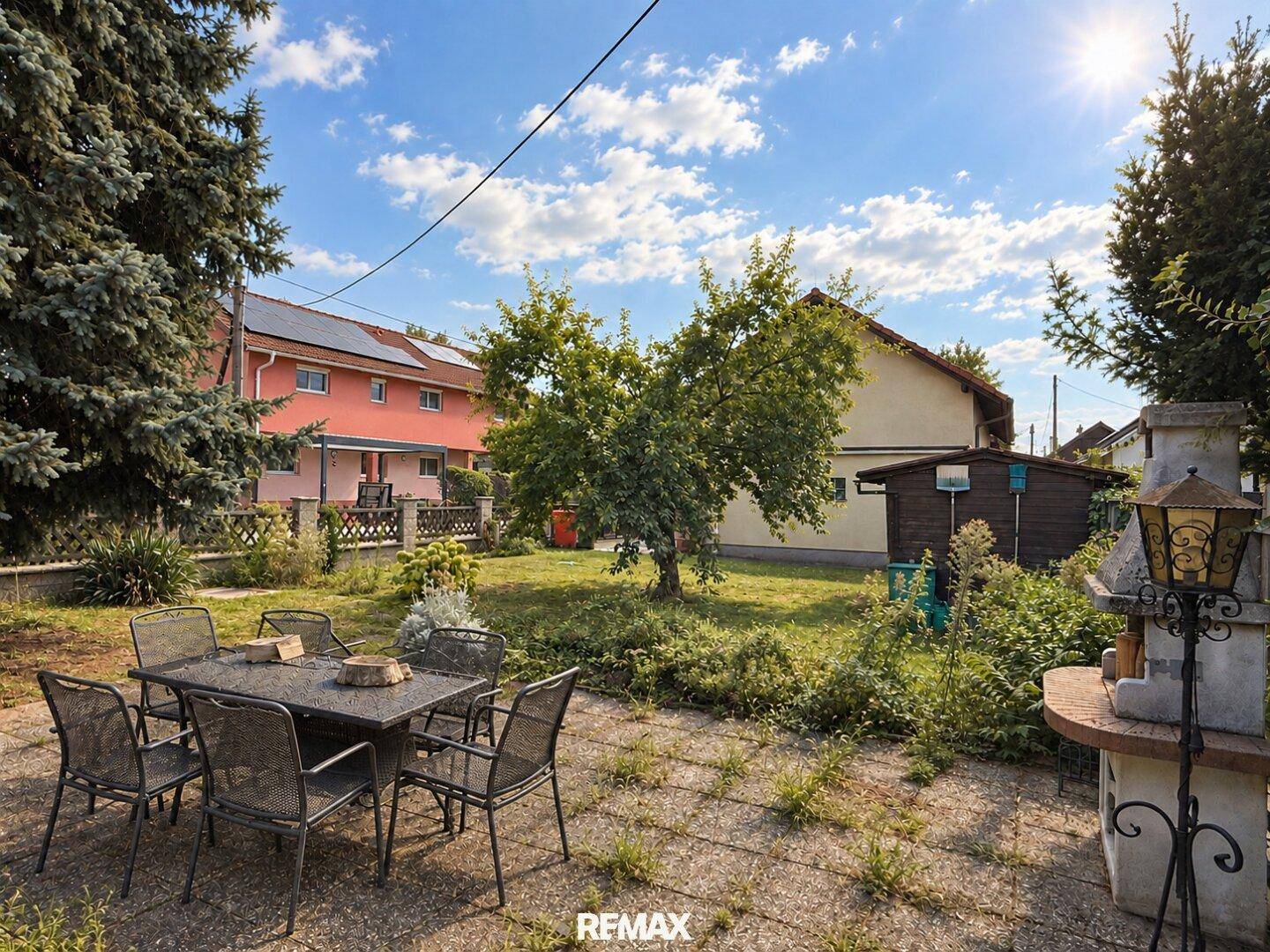Großer Garten mit Sitzbereich, Grillplatz und altem Baumbestand.