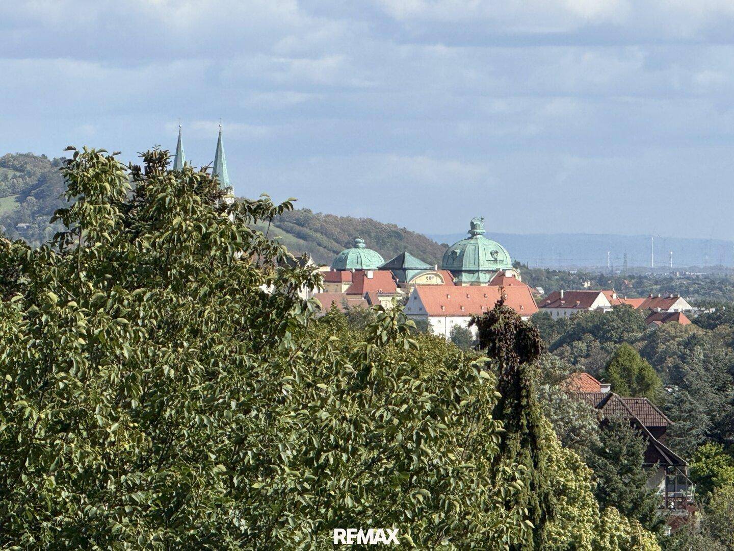 Panoramablick über eine historische Stadt mit markanten Kuppeln und Kirchtürmen in der Ferne.