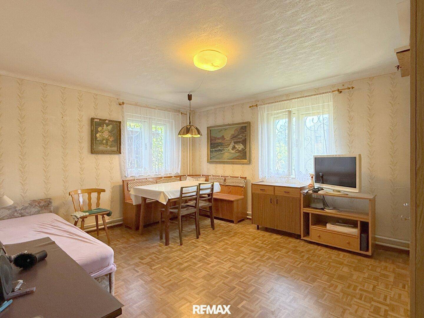 Vielseitiger Raum mit Essbereich, Schlafgelegenheit und Fernseher, ideal als Gästezimmer oder Hobbyraum.